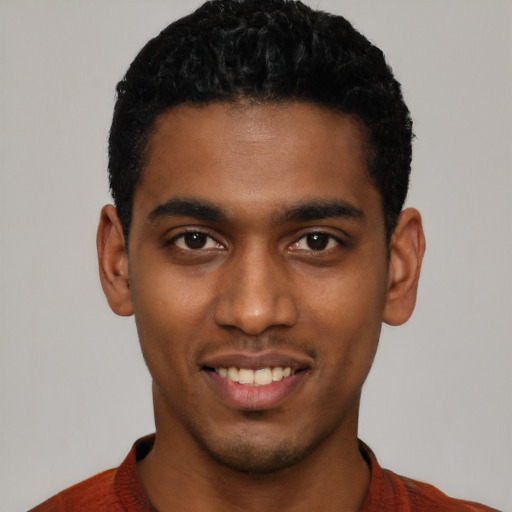 Joyful black young-adult male with short  black hair and brown eyes