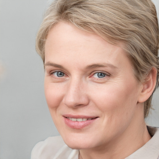 Joyful white young-adult female with short  brown hair and blue eyes