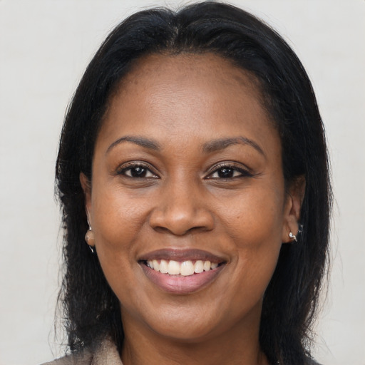 Joyful black adult female with long  brown hair and brown eyes