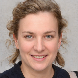 Joyful white young-adult female with medium  brown hair and blue eyes