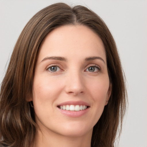 Joyful white young-adult female with long  brown hair and grey eyes