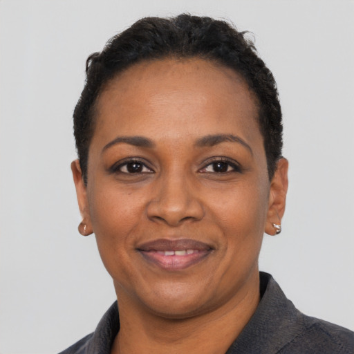 Joyful black adult female with short  black hair and brown eyes