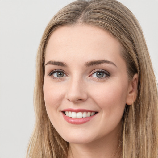 Joyful white young-adult female with long  brown hair and blue eyes