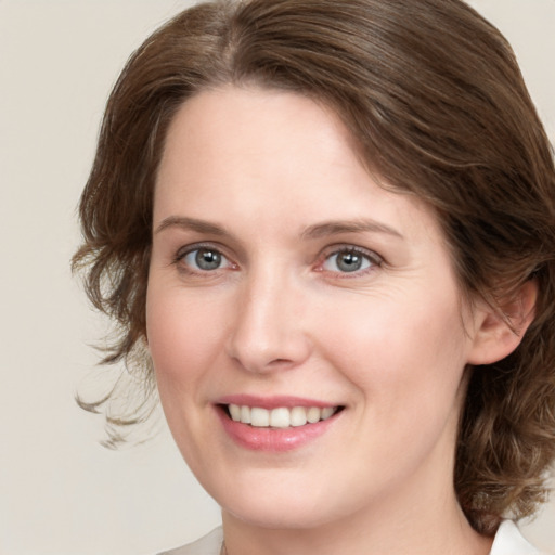 Joyful white young-adult female with medium  brown hair and grey eyes