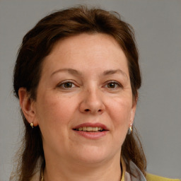 Joyful white adult female with medium  brown hair and blue eyes