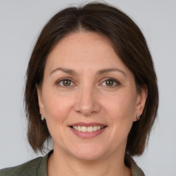 Joyful white adult female with medium  brown hair and grey eyes