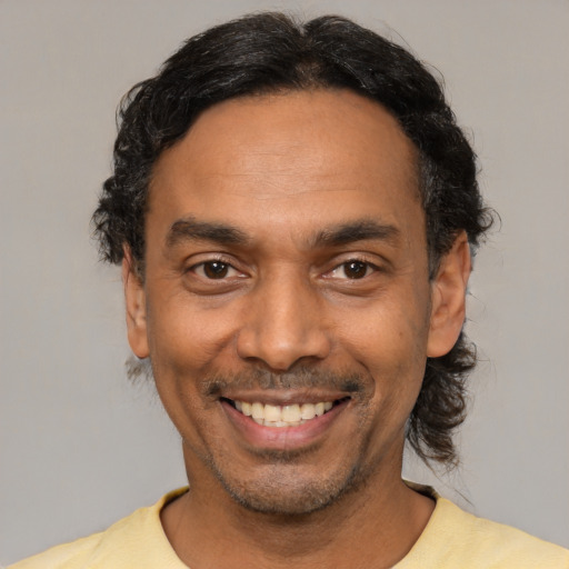 Joyful latino adult male with short  black hair and brown eyes