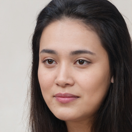 Joyful asian young-adult female with long  brown hair and brown eyes
