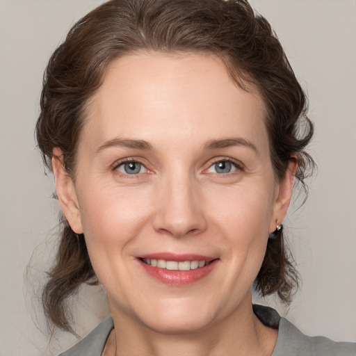 Joyful white adult female with medium  brown hair and grey eyes