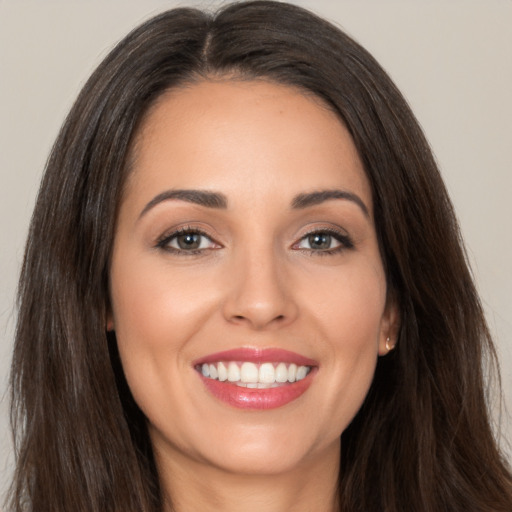 Joyful white young-adult female with long  brown hair and brown eyes