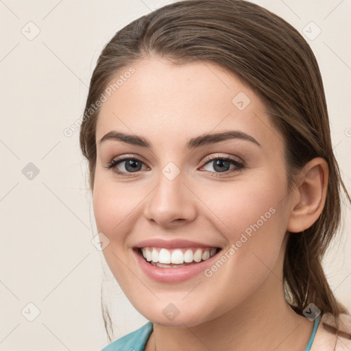 Joyful white young-adult female with medium  brown hair and grey eyes