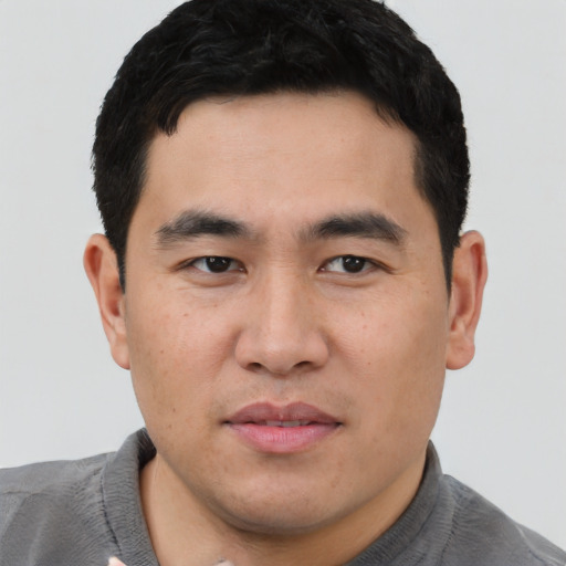 Joyful asian young-adult male with short  black hair and brown eyes