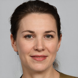 Joyful white adult female with medium  brown hair and grey eyes