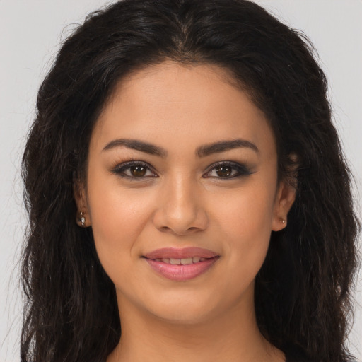 Joyful latino young-adult female with long  brown hair and brown eyes