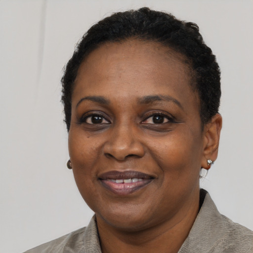 Joyful black adult female with short  black hair and brown eyes