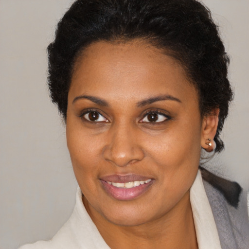Joyful black young-adult female with medium  brown hair and brown eyes