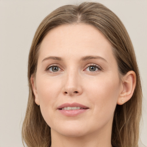 Joyful white young-adult female with long  brown hair and grey eyes