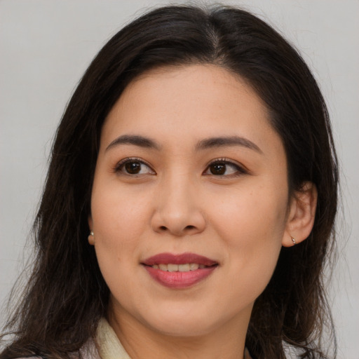 Joyful asian young-adult female with long  brown hair and brown eyes