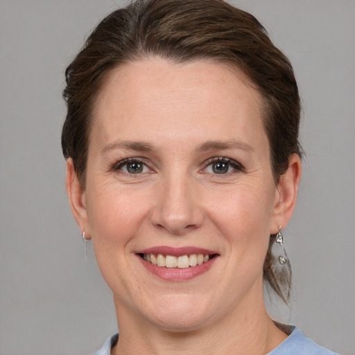 Joyful white adult female with medium  brown hair and grey eyes