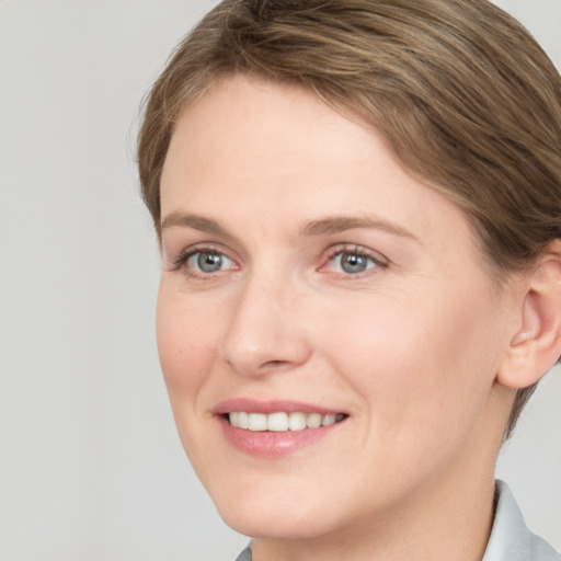 Joyful white young-adult female with short  brown hair and grey eyes