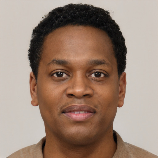 Joyful black young-adult male with short  brown hair and brown eyes