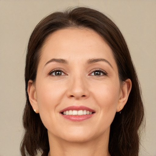 Joyful white young-adult female with long  brown hair and brown eyes