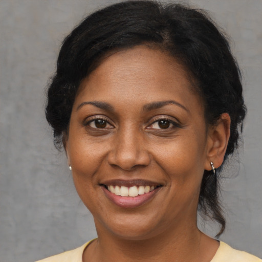 Joyful black adult female with medium  brown hair and brown eyes