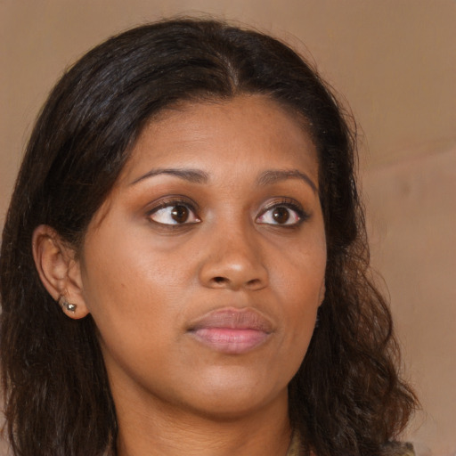 Joyful black young-adult female with long  brown hair and brown eyes