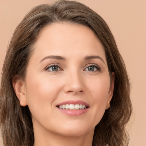 Joyful white young-adult female with long  brown hair and grey eyes