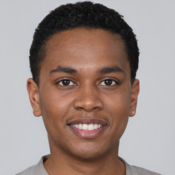 Joyful black young-adult male with short  brown hair and brown eyes