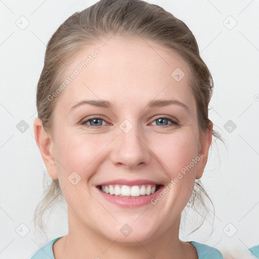 Joyful white young-adult female with medium  brown hair and grey eyes