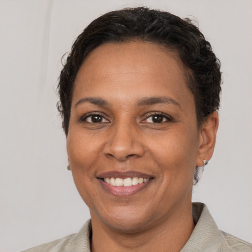 Joyful black adult female with short  brown hair and brown eyes