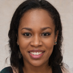 Joyful black young-adult female with long  brown hair and brown eyes