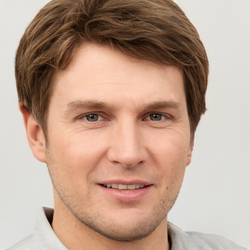 Joyful white adult male with short  brown hair and grey eyes