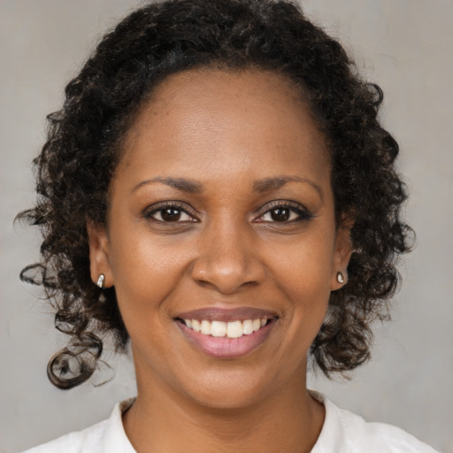 Joyful black young-adult female with medium  brown hair and brown eyes