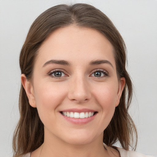 Joyful white young-adult female with medium  brown hair and grey eyes