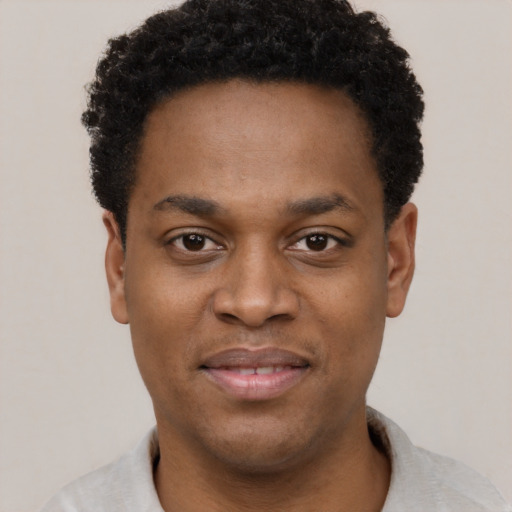 Joyful black young-adult male with short  black hair and brown eyes
