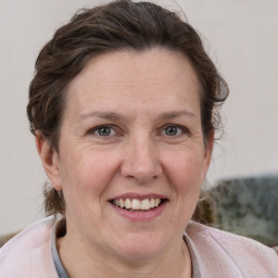 Joyful white adult female with medium  brown hair and grey eyes