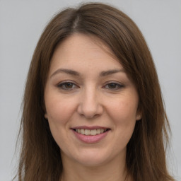 Joyful white young-adult female with long  brown hair and grey eyes