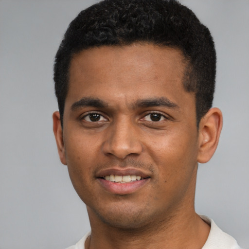 Joyful black young-adult male with short  black hair and brown eyes