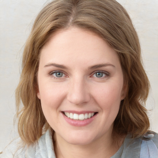 Joyful white young-adult female with medium  brown hair and blue eyes