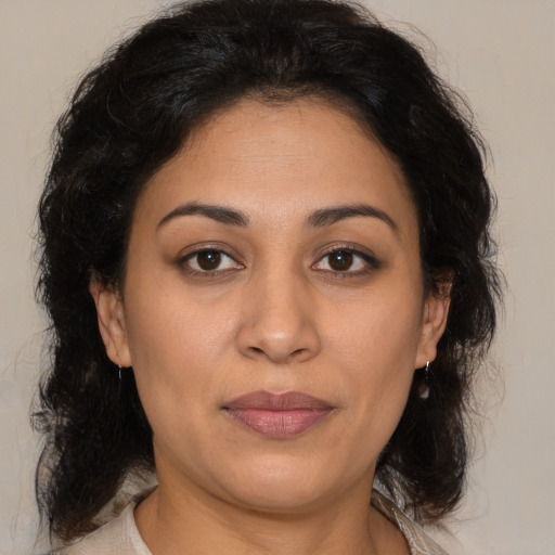 Joyful latino adult female with medium  brown hair and brown eyes