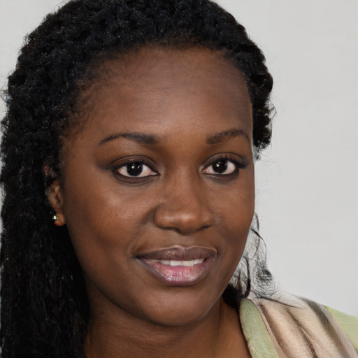 Joyful black young-adult female with long  brown hair and brown eyes