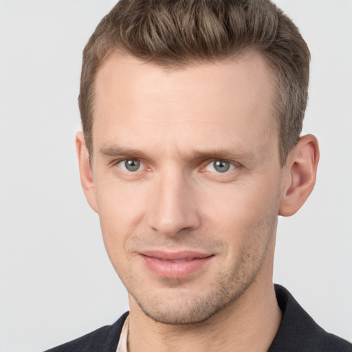 Joyful white young-adult male with short  brown hair and grey eyes