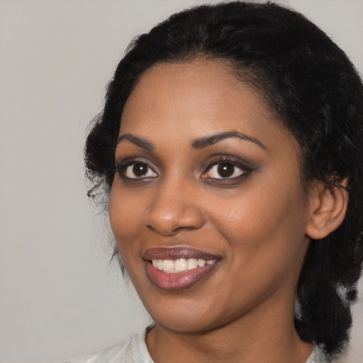 Joyful black young-adult female with medium  black hair and brown eyes