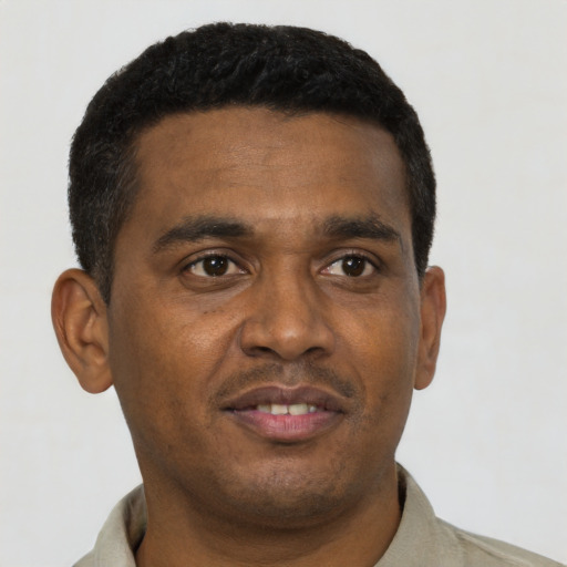 Joyful black young-adult male with short  black hair and brown eyes