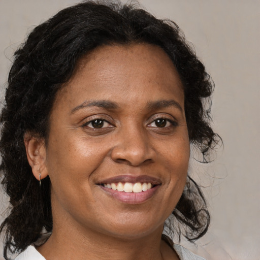 Joyful black young-adult female with medium  brown hair and brown eyes