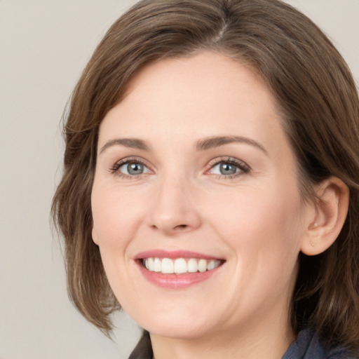 Joyful white young-adult female with medium  brown hair and grey eyes