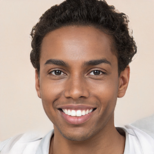 Joyful black young-adult male with short  brown hair and brown eyes