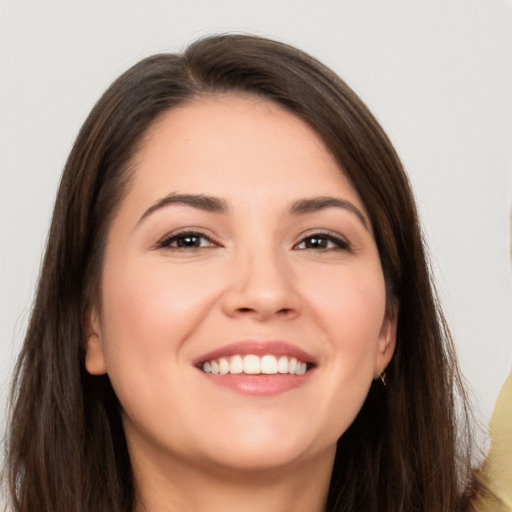 Joyful white young-adult female with long  brown hair and brown eyes